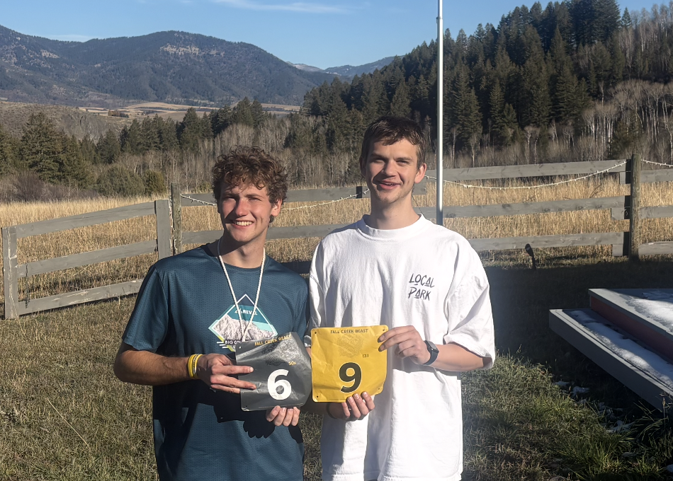 Two finishers holding up bibs 6 and 9 in front of Swan Valley