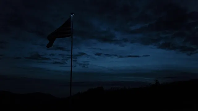 An American flag silhouetted against a deep dawn sky over Swan Valley